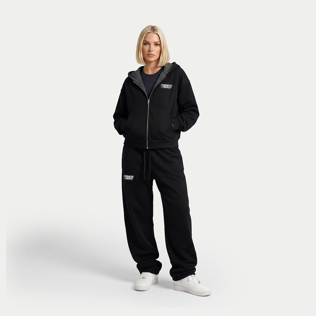 Black zip-up hoodie by Caracas Merch, product view